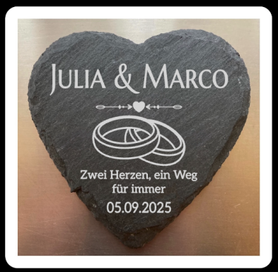 Herzförmiger Stein mit Namen, Hochzeitsdatum und Symbolen für Eheringe.