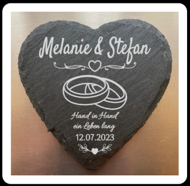 Herzförmiger Stein mit den Namen Melanie & Stefan und Hochzeitsdatum 12.07.2023.