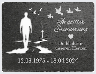 Gedenktafel mit einem Silhouettenbild, Herz und Tauben, Datum und Text zur Erinnerung.