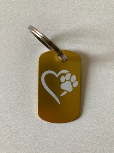 Goldener Anhänger mit einem Herz und einem Pfotenabdruck-Motiv.