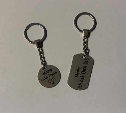 Schlüsselanhänger mit einer Herz-Inschrift und einem dog tag mit Gravur.