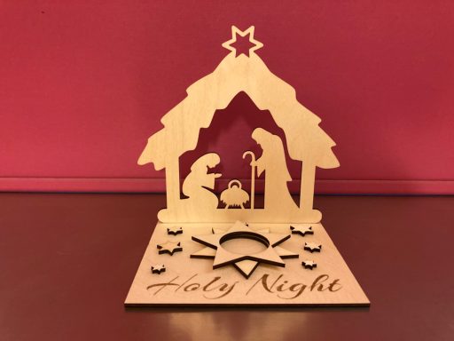 Holzschnitzerei einer Krippenszene mit Christbaumstern und dem Text "Holy Night".