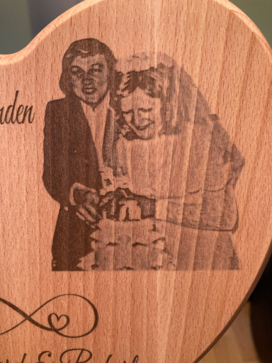 Brautpaar schneidet eine Hochzeitstorte, graviert auf Holz.