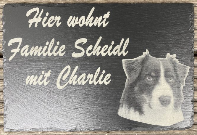Schiefertafel mit der Aufschrift „Hier wohnt Familie Scheidl mit Charlie“ und Hundefoto, graviert.