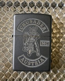Schwarze Zippo-Feuerzeug mit dem Logo "Crusader MC Austria"graviert.