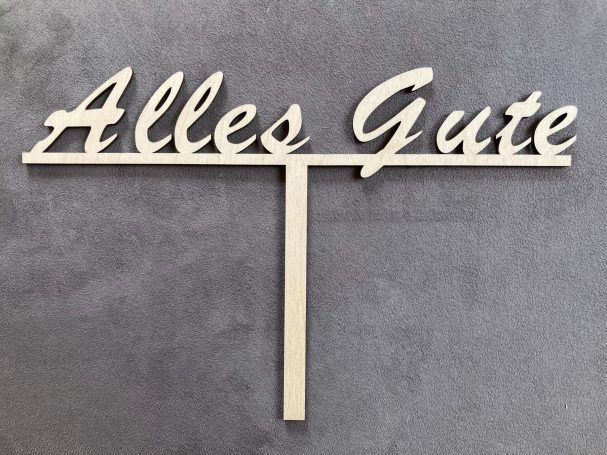 Holzschriftzug „Alles Gute“ auf grauem Hintergrund.