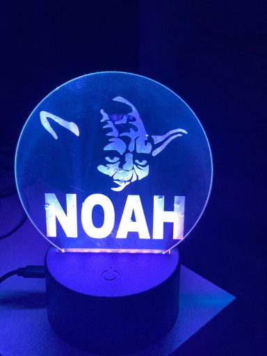 Leuchtende LED-Tischlampe mit dem Namen "NOAH" und einem stilisierten Kopf.