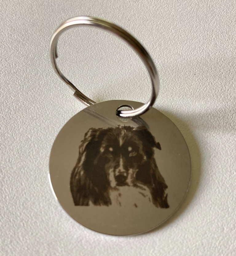 Metallanhänger mit graviertem Hundebild.