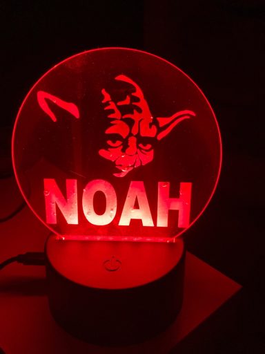 Leuchtende rote Lampe mit dem Namen "NOAH" und einem verschmitzten Gesicht.