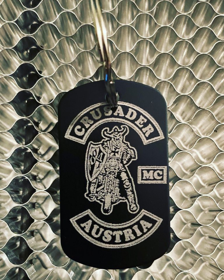 Schwarzer Schlüsselanhänger mit dem Aufdruck „Crusader Austria MC“ und einem Ritter-Symbol.