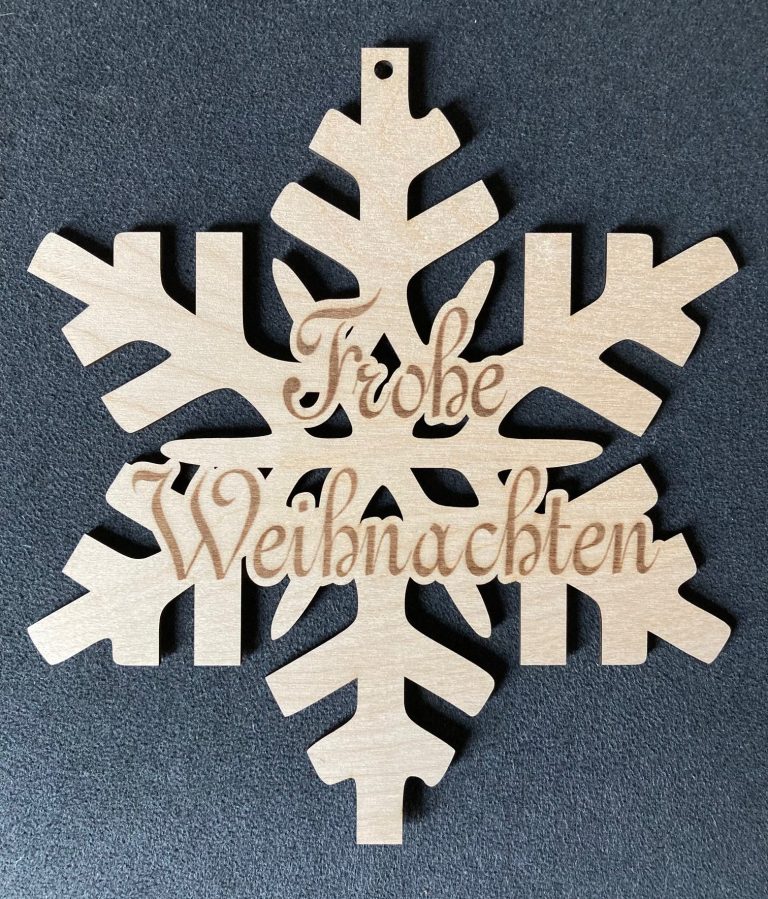 Holzschneeflocke mit der Aufschrift "Frohe Weihnachten".
